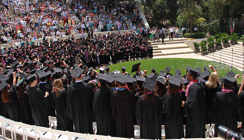 This is a photograph of students at their outdoor university graduation ceremony.