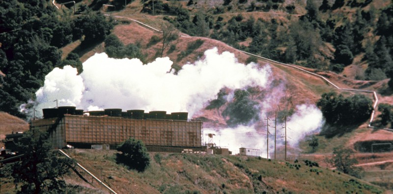 A photograph shows an energy plant on a hillside with clouds of white steam immediately above the plant