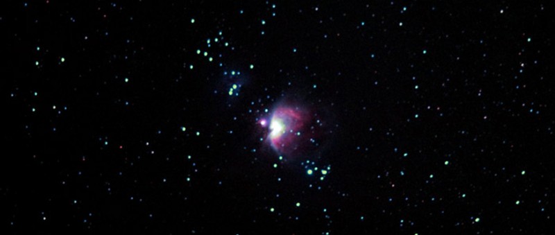 Night sky with bright Orion Nebula cluster in the center amongst the group of stars.